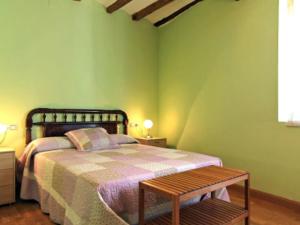 a green bedroom with a bed and a bench at Casa Chaparrete in Deza