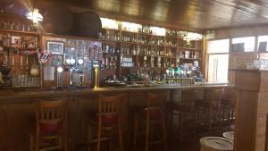 un bar con una fila de sillas en una habitación en Skellys en Ballymahon