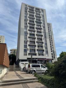 a tall building with cars parked in front of it at Grand studio lumineux proche gare in Saint-Ouen-lʼAumône