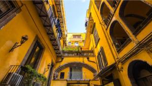 een steegje tussen twee gebouwen met een geel gebouw bij San Gregorio Studio in Napels