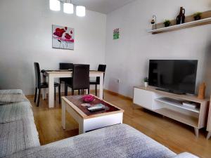 salon z telewizorem i stołem z krzesłami w obiekcie Apartamento Padial w mieście Nerja