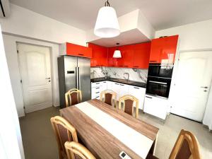 a kitchen with red cabinets and a table with chairs at Vila Sedef Costinești in Costinesti