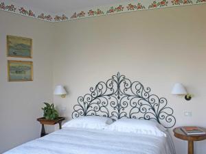 a white bed with a metal headboard in a bedroom at Villa Rubino Apartment con giardino e jacuzzi vista lago in Stresa