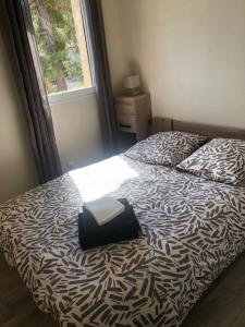 a bedroom with a bed with a black and white comforter at La catane in Andon