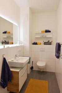 a white bathroom with a sink and a toilet at Ostseeecke in Kappeln