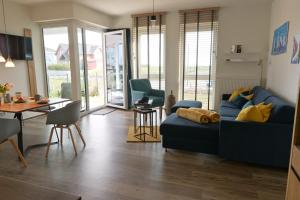 a living room with a blue couch and a table at Ostseeecke in Kappeln