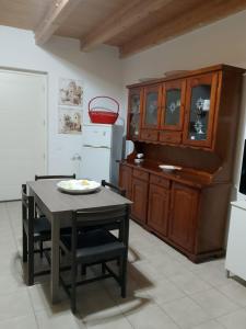 cocina con mesa, sillas y armario en La Casetta Di Liù, en Villagrazia