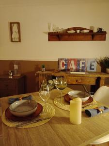 a wooden table with wine glasses and plates on it at Studette proche Meaux-Disneyland-A4 in Saint-Jean-les-Deux-Jumeaux