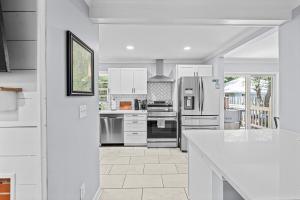 a kitchen with white appliances and a white counter top at New Owners! Downtown Corner Cottage-Pet Friendly in Southern Pines