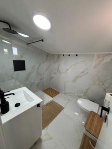 ein weißes Badezimmer mit Waschbecken und Toilette in der Unterkunft Villas Sossego in Porto Santo + 31 Fotos