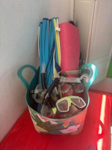 un récipient rempli de fournitures de bureau sur une table rouge dans l'établissement Aruba Cottage, à Oranjestad