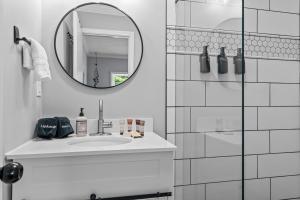 a white bathroom with a sink and a mirror at New Owners! Downtown Corner Cottage-Pet Friendly in Southern Pines +27 photos