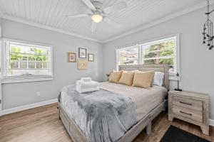 a bedroom with a bed and two windows at New Owners! Downtown Corner Cottage-Pet Friendly in Southern Pines