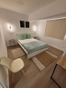 ein kleines Schlafzimmer mit einem Bett und einem Stuhl in der Unterkunft Villas Sossego in Porto Santo