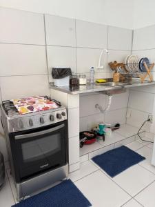 a small kitchen with a stove and a counter at Microcasa 1 - Centro Maricá in Maricá