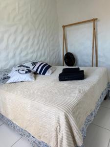 a bed with two pillows on top of it at Microcasa 1 - Centro Maricá in Maricá