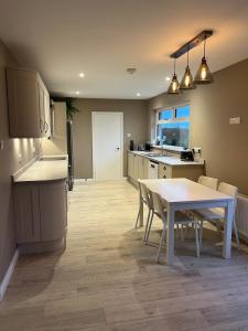 a kitchen and dining room with a table and a table and chairs at Ardnageeha in Doagh +20 photos