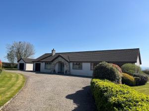 a large white house with a driveway at Ardnageeha in Doagh