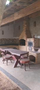 a group of picnic tables in front of a brick oven at Sítio do patinhas in Nova Iguaçu