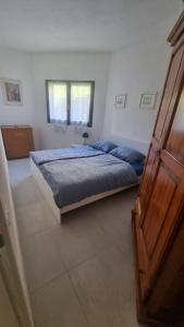 ein Schlafzimmer mit einem Bett mit blauen Laken und einem Fenster in der Unterkunft Ferienunterkunft in Costa Rei in Costa Rei