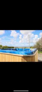 a large swimming pool with blue water in it at Burry House North Gower in Llanmorlais