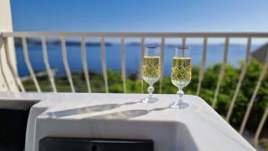 deux verres de champagne posés sur une table sur un balcon dans l'établissement Arba Seaview Residences Apartments, à Mlini