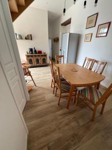 a dining room with a wooden table and chairs at Gîte Villa Santina in Piquecos