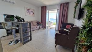 un salon avec un canapé, une table et des chaises dans l'établissement Arba Seaview Residences Apartments, à Mlini
