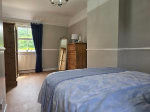 ein Schlafzimmer mit einem Bett, einem Fenster und einer Kommode in der Unterkunft Newly Renovated Country Cottage in Portadown