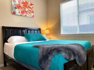 a bedroom with a large bed with a blue blanket at One Story Pet & Family Friendly Fireplace in West Sacramento