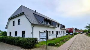 a white house with a sign in front of it at CBlue "Zickerstuuv", Wasserblick, in der Natur, Grill in Groß Zicker