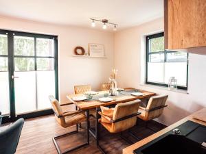 a dining room with a table and chairs at CBlue "Zickerstuuv", Wasserblick, in der Natur, Grill in Groß Zicker +12 photos