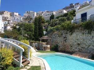 a swimming pool in front of a hill with houses at Hotel Elisa - Spiaggia Privata Inclusa in Peschici