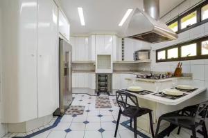 a kitchen with a table and some chairs in it at Quarto privativo 5 minutos metrô com Piscina e churrasqueira in Sao Paulo