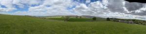 ein grüner Hügel mit einem Zaun auf einem Feld in der Unterkunft Estatesmen Lodge, Hillside Farm in Kirkby Stephen