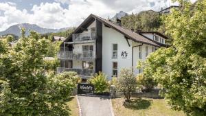 ein weißes Haus mit Bäumen davor in der Unterkunft Kiechls Homebase - Adults only in Tarrenz