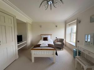 ein Schlafzimmer mit einem Bett, einem Stuhl und einem Kronleuchter in der Unterkunft Estatesmen Lodge, Hillside Farm in Kirkby Stephen + 36 Fotos