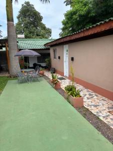 a patio with a table and chairs and an umbrella at Alojamiento Santino, en Cataratas del Iguazu in Puerto Iguazú