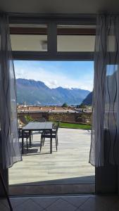 リーヴァ・デル・ガルダにあるGardaSunrise Apartment - Riva del Gardaの窓からテーブルとベンチの景色を望めます。