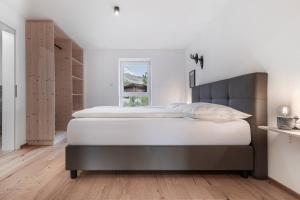 ein Schlafzimmer mit großem Bett und Fenster in der Unterkunft Kiechls Homebase - Adults only in Tarrenz