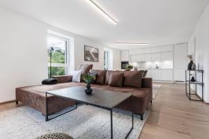 ein Wohnzimmer mit einem braunen Sofa und einem Tisch in der Unterkunft Kiechls Homebase - Adults only in Tarrenz