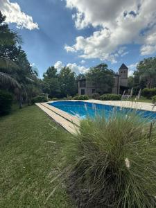 einen Pool in einem Garten mit Gras in der Unterkunft Los Alerces in Villa Urquiza