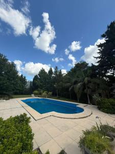 ein blauer Pool in einem Garten mit Bäumen in der Unterkunft Los Alerces in Villa Urquiza + 8 Fotos