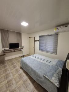 Churuquita GrandeFinca Agroturística La Amistad的一间卧室，里面有一张床和一台平板电视