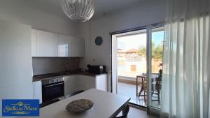a kitchen with a table and a view of a balcony at Stella del Mare in Silvi Marina