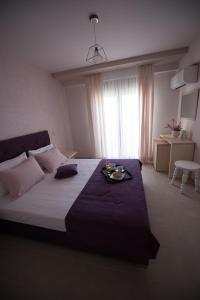 Un dormitorio con una cama con una bandeja de comida. en Aloe Apartments Ammouliani en Amoliani