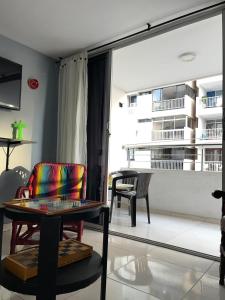 Una sala de estar con una silla y una mesa. en Hermosa Vista al Mar en Rodadero, en Gaira