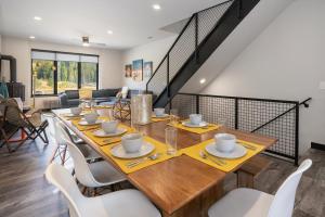 un comedor con una larga mesa de madera y sillas blancas en Experience luxury and adventure at Row 41 nestled in the heart of Winter Park Colorado, en Winter Park