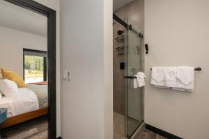 Un baño con ducha de cristal y una cama. en Experience luxury and adventure at Row 41 nestled in the heart of Winter Park Colorado, en Winter Park 33 fotos más