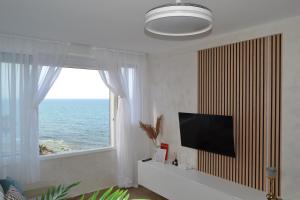 ein Wohnzimmer mit einem TV und einem großen Fenster in der Unterkunft Vista Mar Torrevieja in Torrevieja